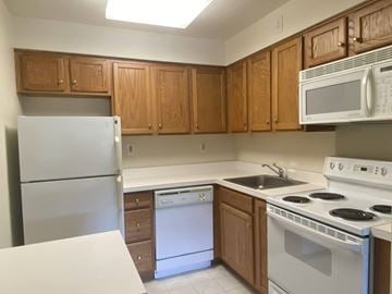 Parlin apartment for rent - A kitchen with white appliances and wooden cabinets.