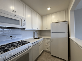 Nutley apartment for rent - A white kitchen with a stove, microwave, and refrigerator.