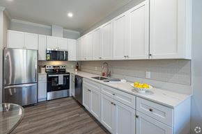 Denville apartment for rent - A modern kitchen with white cabinets and a stainless steel refrigerator.at Station Village at Denville, Denville, NJ 07834