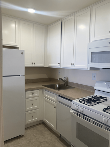Passaic apartment for rent - A kitchen with white cabinets and appliances.