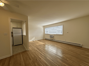 Passaic apartment for rent - A room with wooden floors and a window with blinds.