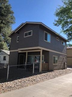 Flagstaff house for rent - a gray house with a porch and a sidewalk