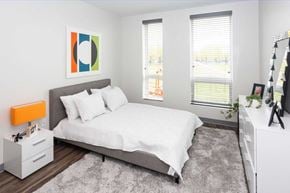 Boston apartment for rent - Two tall windows, carpet flooring, modern interior design.