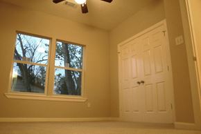Houston apartment for rent - A room with a white door and a window with trees visible outside.
