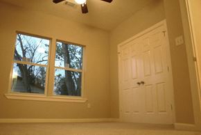 Houston apartment for rent - A room with a white door and a window with trees visible outside.