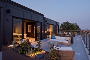 Washington apartment for rent - a roof terrace with couches and chairs and a building with glass doors