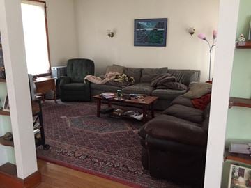 Boston apartment for rent - A living room with a grey couch and a green chair.