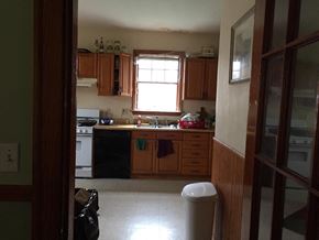 Boston apartment for rent - A kitchen with wooden cabinets and a black dishwasher.