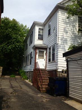 Boston apartment for rent - A white house with a blue door and a red staircase.