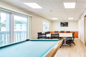 Jacksonville apartment for rent - conference table and chairs with TV and pool table
