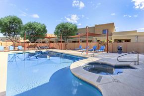 Tucson apartment for rent - A swimming pool with a hot tub and lounge chairs.