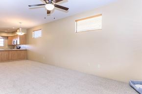 Tucson apartment for rent - A room with a ceiling fan and a window with blinds.