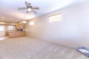 Tucson apartment for rent - A spacious room with a ceiling fan and a carpeted floor.