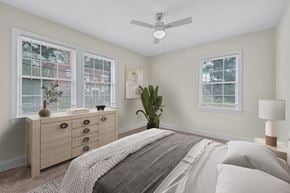 Washington apartment for rent - A bedroom with a bed, dresser, and ceiling fan.