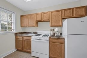 Washington apartment for rent - A kitchen with wooden cabinets and a white stove.