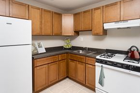Silver Spring apartment for rent - a kitchen with white appliances and wooden cabinets