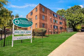 Washington apartment for rent - A sign for Friendship Crossing is in front of a brick building.