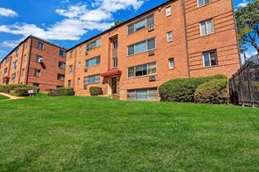 Washington apartment for rent - A red brick building with a green lawn in front.