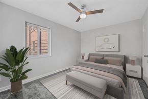 Washington apartment for rent - A bedroom with a bed, a bench, and a plant.
