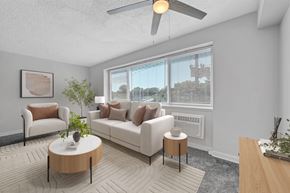 Washington apartment for rent - A living room with a white couch, a coffee table, and a ceiling fan.