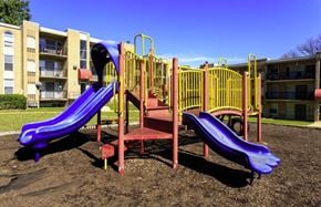 Washington apartment for rent - A playground with a purple slide and a red and yellow structure.