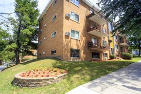 Washington apartment for rent - a flower garden in front of a brick apartment building