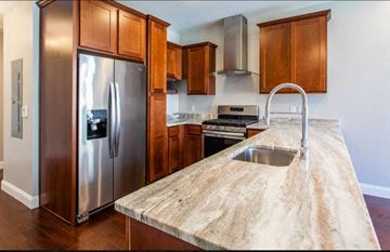 Pittsburgh apartment for rent - A kitchen with a stainless steel refrigerator and a marble countertop.