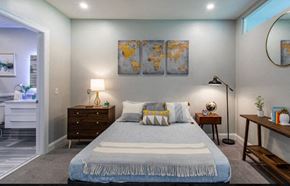 Pittsburgh apartment for rent - A bedroom with a large bed, a nightstand, a side table, and a painting on the wall.