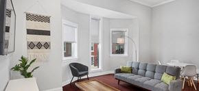 Philadelphia apartment for rent - a living room with a couch and a table and three windows