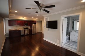 Philadelphia apartment for rent - an empty living room with a ceiling fan and a kitchen