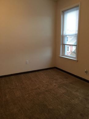 Philadelphia apartment for rent - an empty room with a window and a brown carpet
