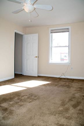 Philadelphia apartment for rent - an empty living room with a ceiling fan and a window