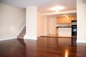 Philadelphia apartment for rent - an empty living room with a staircase and a kitchen