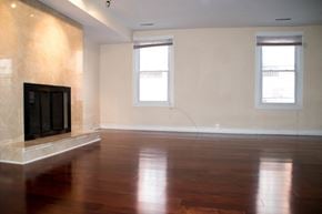 Philadelphia apartment for rent - an empty living room with a fireplace and wooden floors