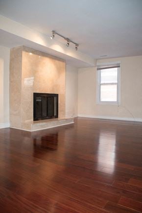 Philadelphia apartment for rent - an empty living room with a fireplace and wooden floors