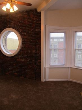 Philadelphia apartment for rent - a living room with a round window and a brick wall