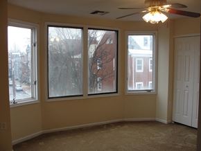 Philadelphia apartment for rent - a living room with four windows and a ceiling fan