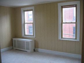 Philadelphia apartment for rent - an empty room with a radiator and two windows