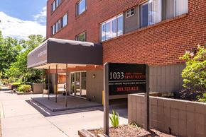 Denver apartment for rent - The image shows a building with a sign that reads "1033 apartments" and a phone number.