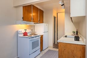 Denver apartment for rent - A small kitchen with a white oven and a white fridge.