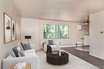 Denver apartment for rent - A living room with a white couch, a coffee table, and a painting on the wall.