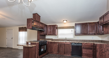Aurora apartment for rent - a kitchen with wooden cabinets and a black dishwasher and a sink