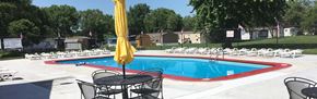 Lincoln apartment for rent - a swimming pool with chairs and a table in front of it