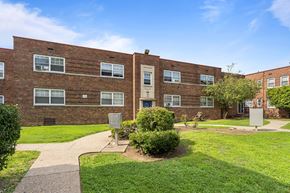 Philadelphia apartment for rent - a brick building with a green lawn and sidewalk in front of it