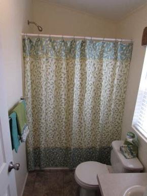 Rock Springs apartment for rent - A bathroom with a toilet, shower curtain, and a towel hanging on the door.