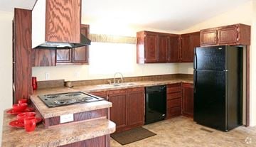 Rock Springs apartment for rent - A kitchen with brown cabinets and a black refrigerator.