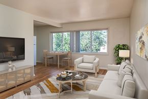Denver apartment for rent - A living room with a white couch, a wooden coffee table, and a large window.