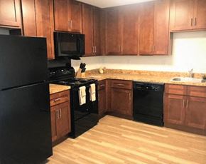 Centreville apartment for rent - a kitchen with black appliances and wooden cabinets