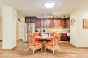 Port Charlotte apartment for rent - community kitchen with table, chairs, fridge, cabinetry, and track lighting