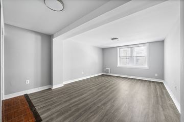 Philadelphia apartment for rent - A spacious room with wooden flooring and a window.